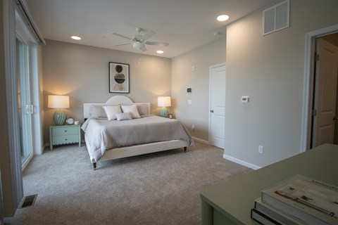 A bedroom with a bed, nightstand, and lamp.