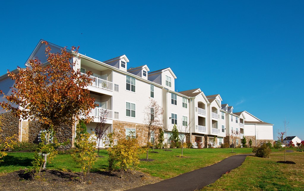 an apartment building with a sidewalk in front of it