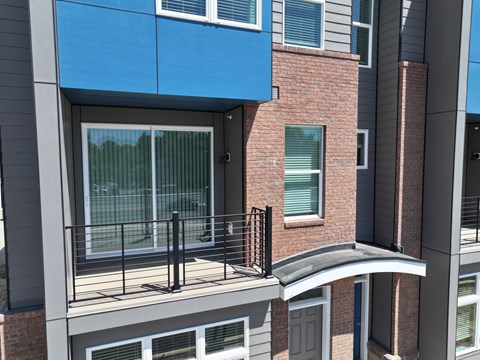 A balcony with a black railing and a glass door.