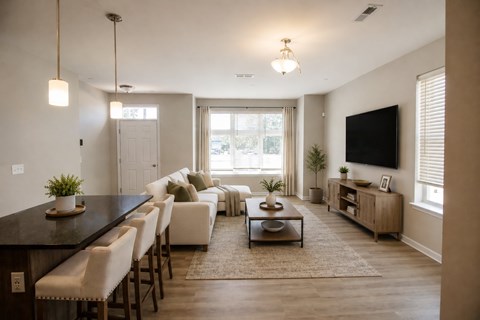 A modern living room with a black countertop and white furniture.