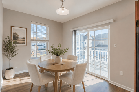 A dining room with a table and chairs.