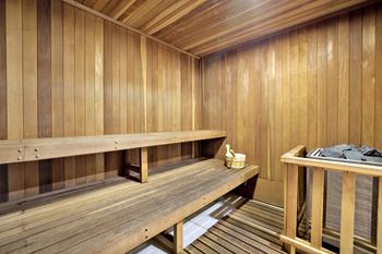 A wooden sauna with benches and a table with towels.