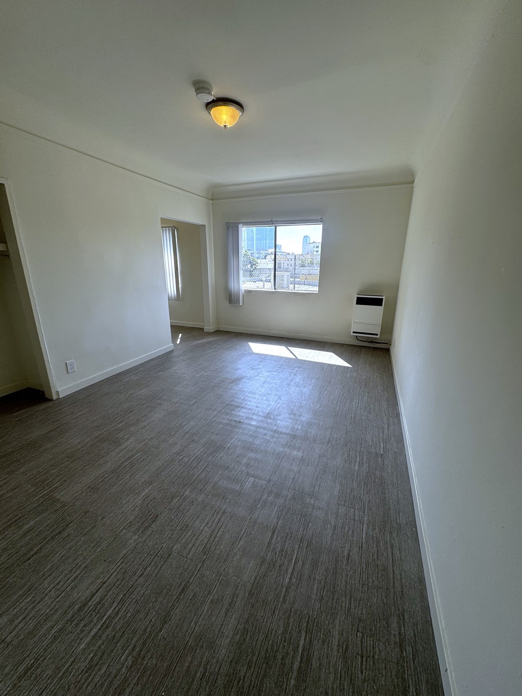 A room with a window and a light on the ceiling.