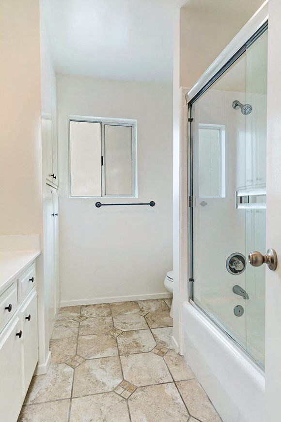 Full bath and shower featuring towel rod and cabinetry