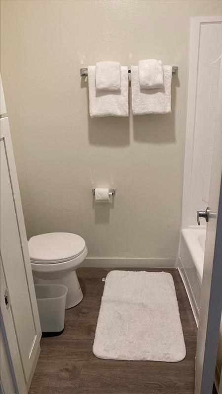 a bathroom with a toilet and two white towels