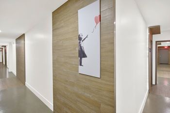 A hallway with a painting of a woman holding a heart-shaped balloon.