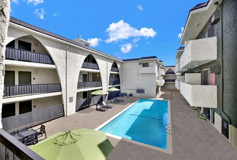 A swimming pool is surrounded by a concrete floor and a green umbrella.