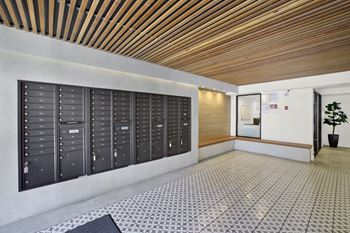 A long hallway with a row of mailboxes on the wall.