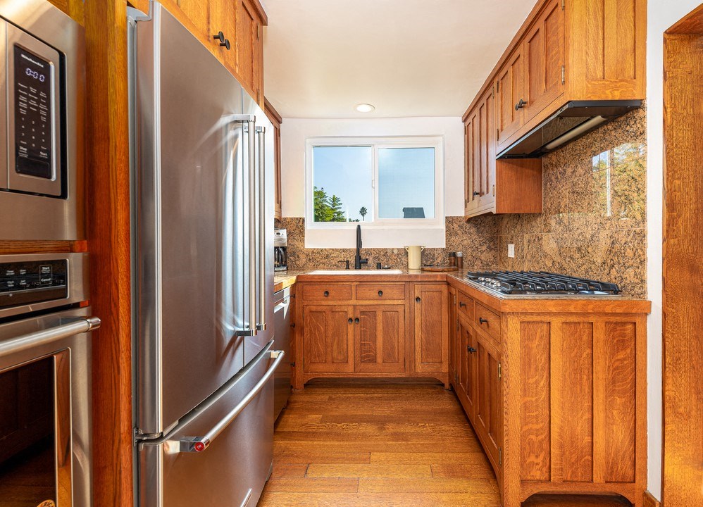 a kitchen with wooden cabinets and stainless steel appliances