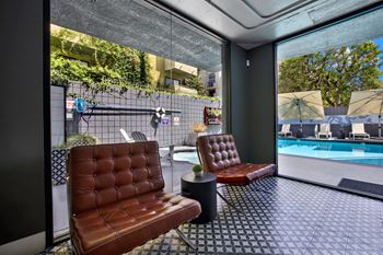 Two brown leather chairs are placed on a tiled floor.