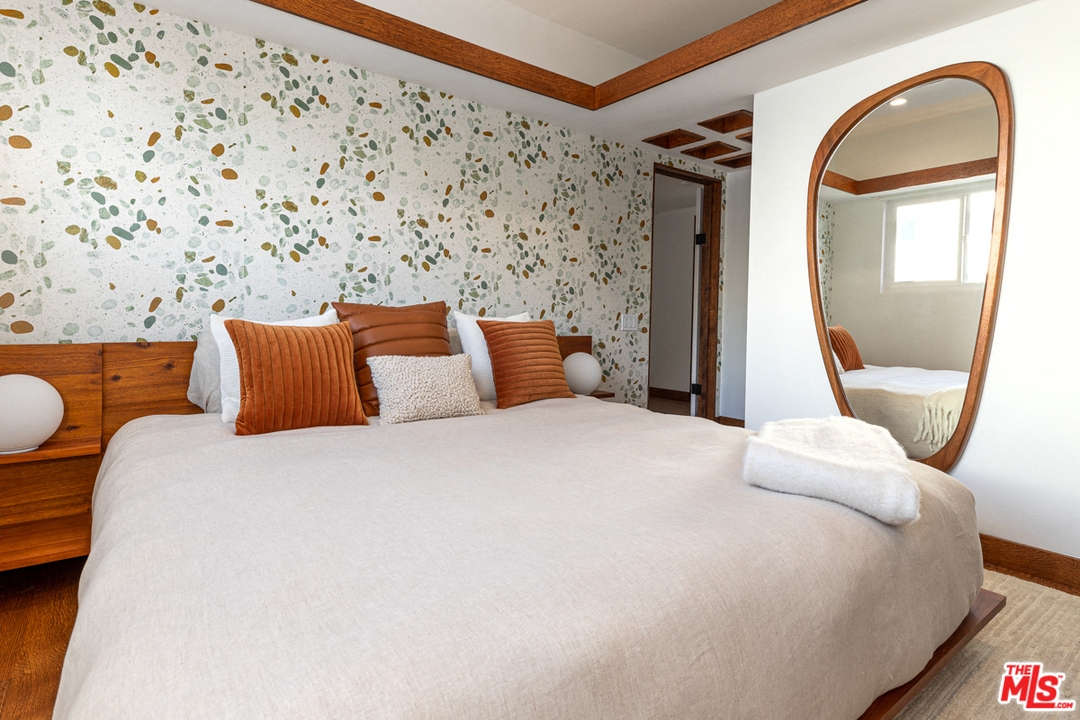 a bedroom with a large bed and a mirror