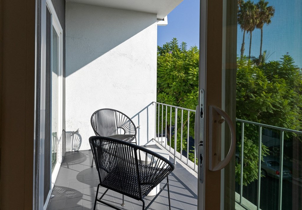 a view of the balcony from the door of a hotel room