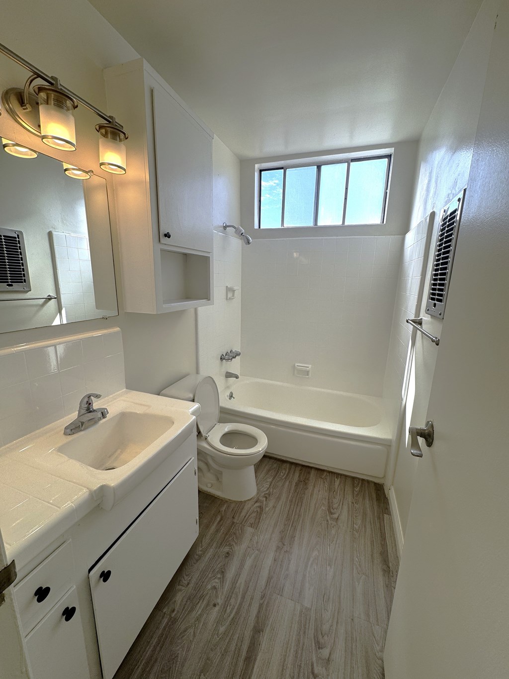 A white bathroom with a sink, toilet, and bathtub.