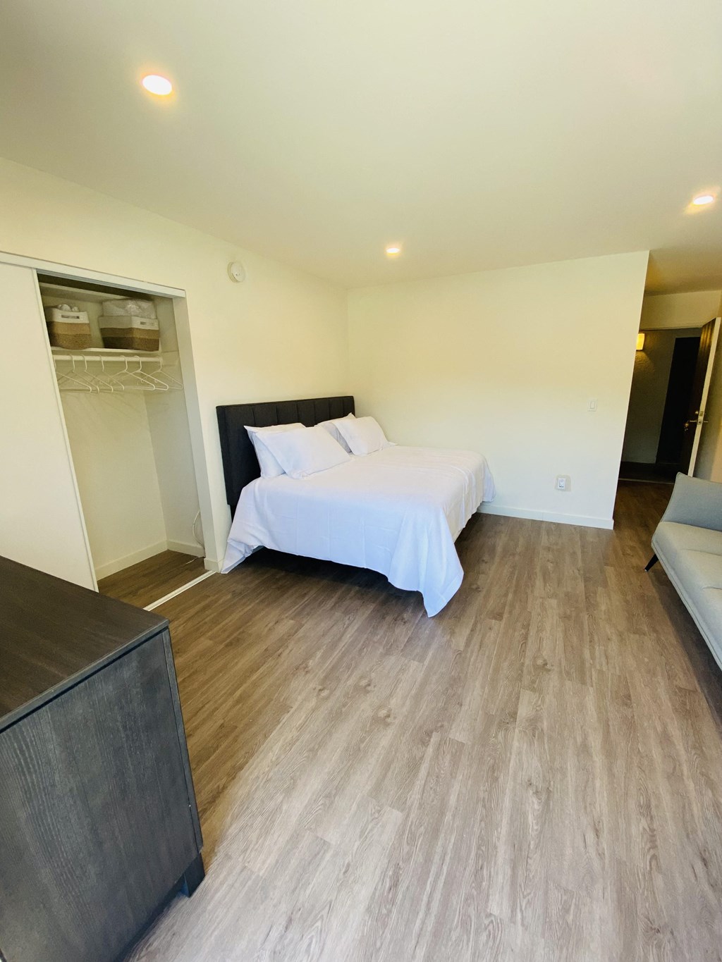 a bedroom with a white bed and a wooden floor