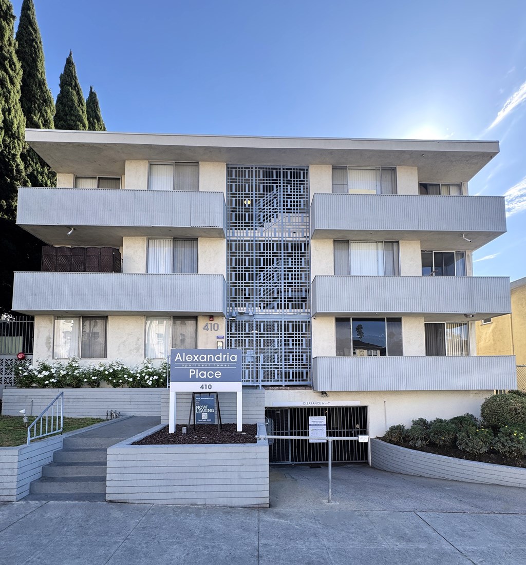 A modern building with the sign "Alexandria Place 410" in front of it.