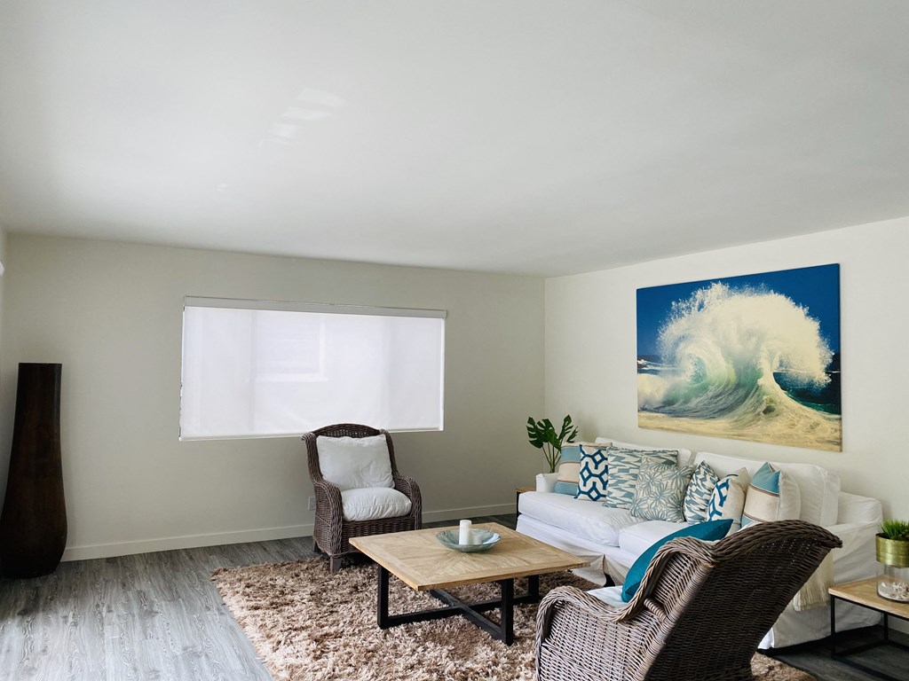 Open living room fits center table, end table, sofa, and two accent chairs with area rug