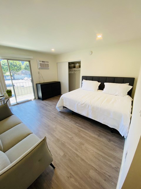 a bedroom with a bed and a couch in a room