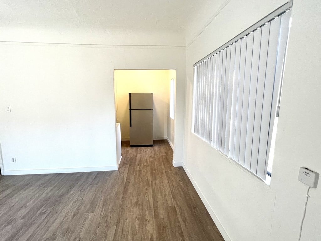 Refrigerator view from the living space, windows with white blind slats