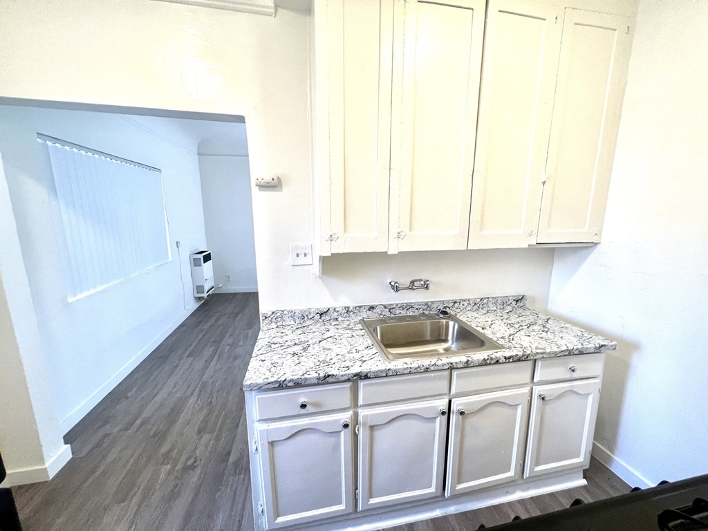 Kitchen counter top with sink and white upper cabinets