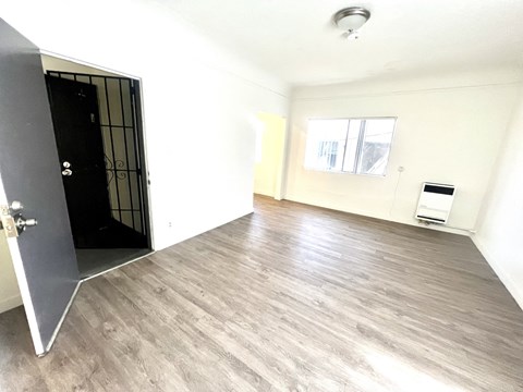an empty living room with white walls and a black door