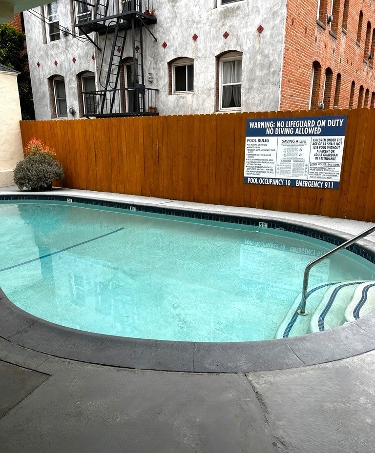A pool with a warning sign on the wall.