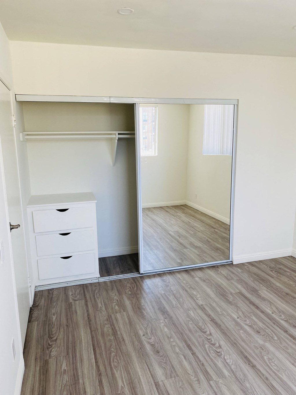 an empty bedroom with a mirror and a closet