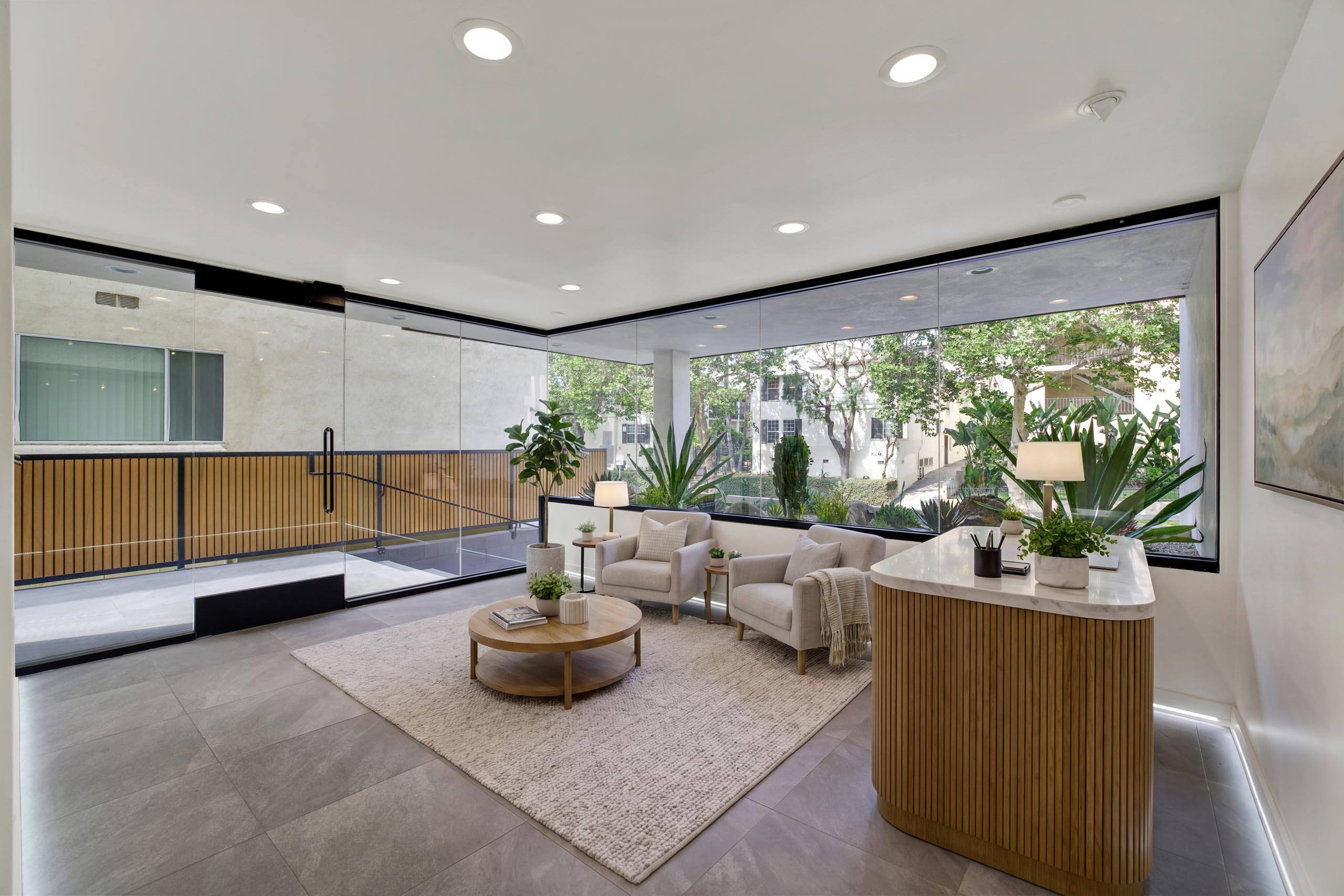 A modern living room with a wooden coffee table and a large window.