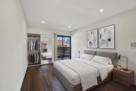 A bedroom with a large bed and a wooden nightstand.