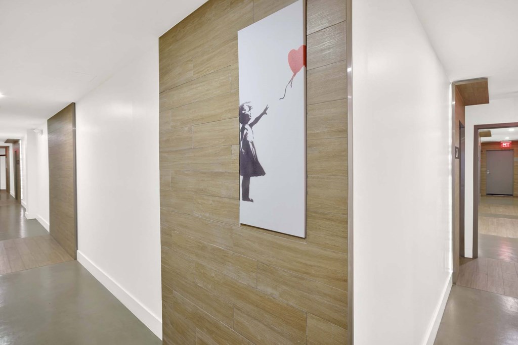 A hallway with a painting of a woman holding a heart-shaped balloon.
