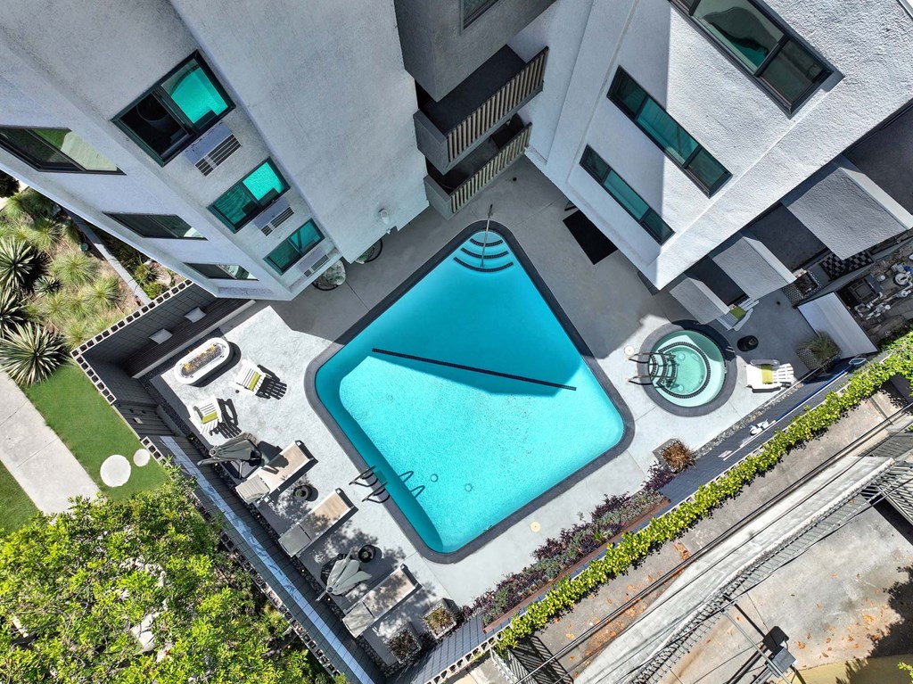 A swimming pool is surrounded by a concrete building.