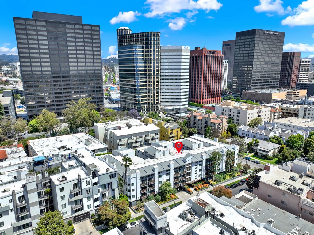 A red marker is placed on a white building in the middle of a cityscape.
