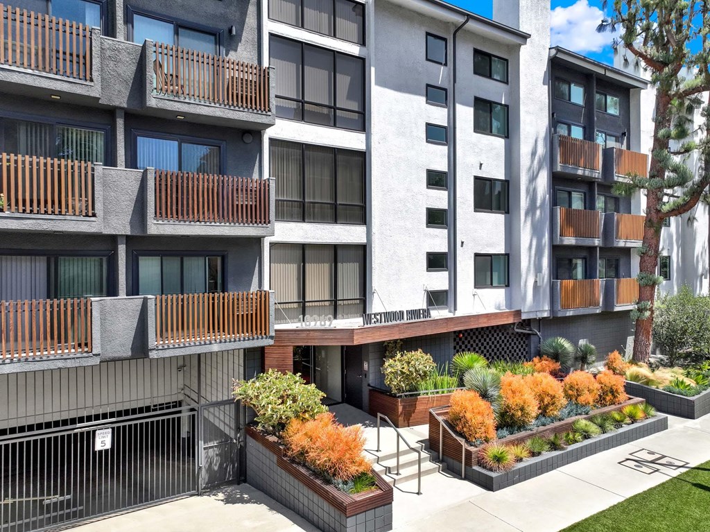 A modern apartment building with a well-maintained outdoor garden area.