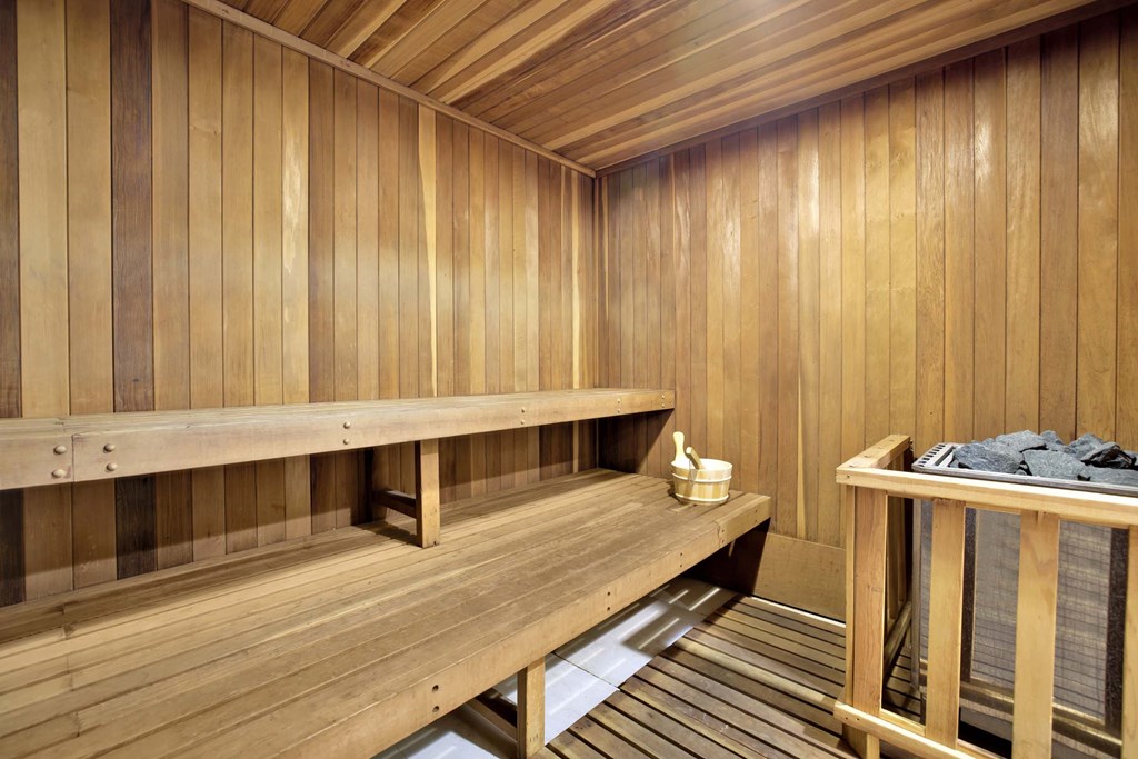 A wooden sauna with benches and a table with towels.