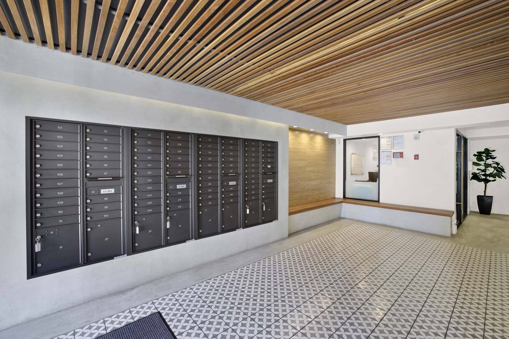 A long hallway with a row of mailboxes on the wall.