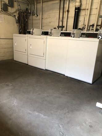 Two washers and two dryers located in the laundry facility in the parking garage