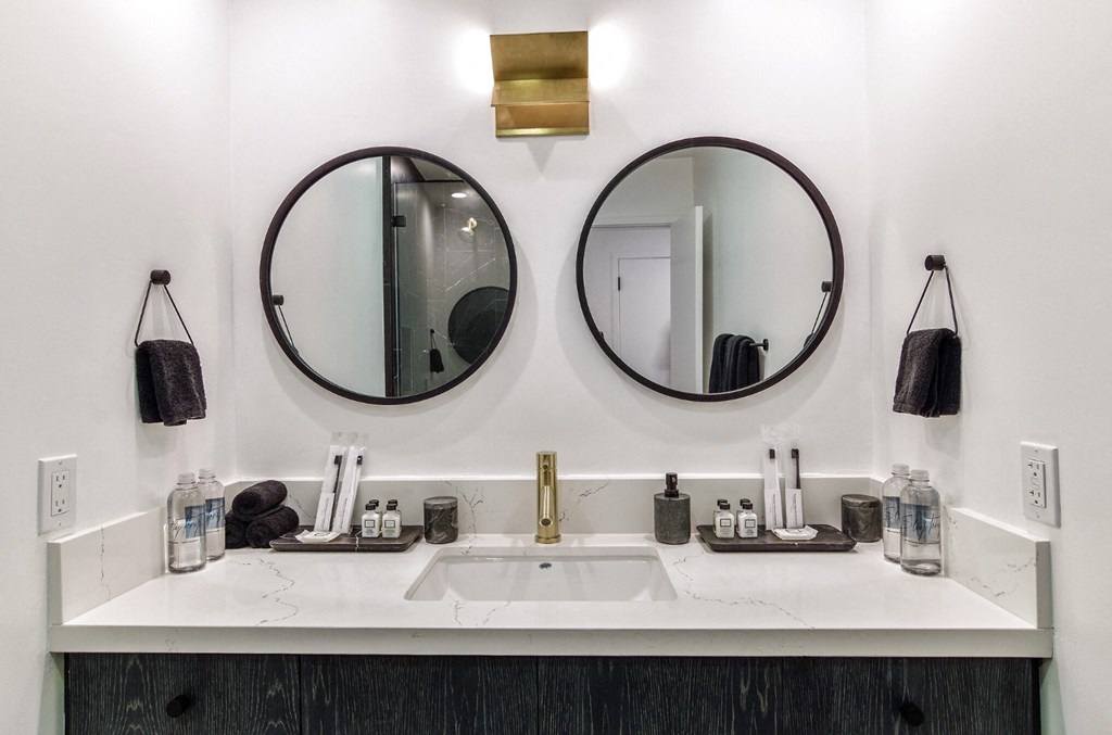 two mirrors above a bathroom sink in a hotel room