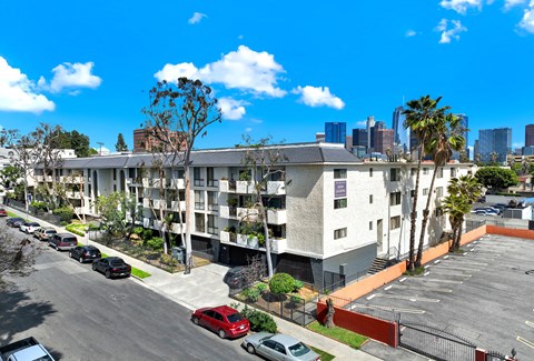 A parking lot with cars and a building in the background.
