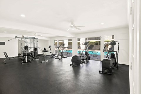 A spacious gym with a variety of equipment including treadmills, stationary bikes, and weight machines.