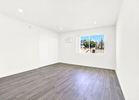 A room with a wooden floor and a picture on the wall.