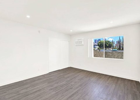 A room with a window showing a view of a cityscape.