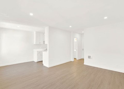 A white room with a wooden floor and a white cabinet.