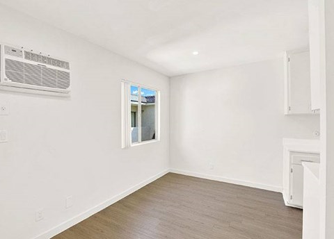 A room with a window and a wall-mounted air conditioner.