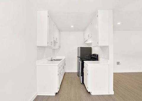 A kitchen with white appliances and cabinets.