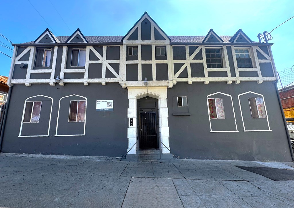 A building with a black and white facade has a black door and windows.