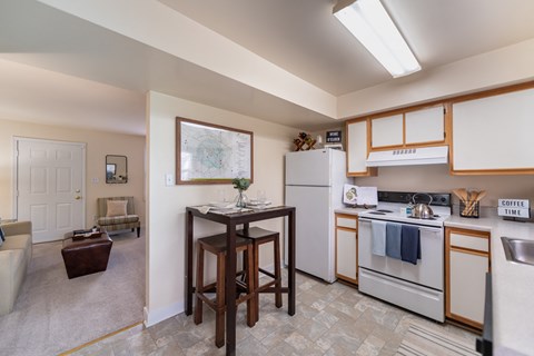 a kitchen with white appliances and a table in the center of the room