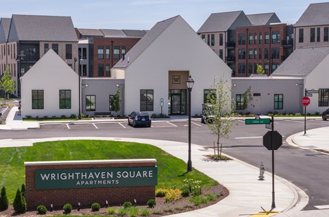 A sign for Wrighthaven Square Apartments is in front of a building.