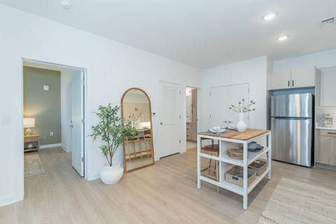 A kitchen with a table and a plant in a vase.