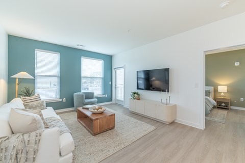 A living room with a white couch and a wooden coffee table.