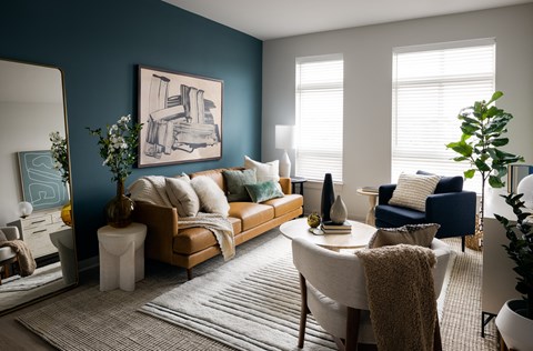 a living room with blue walls and a tan couch