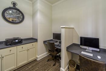 A room with a desk, chair, and a clock on the wall.